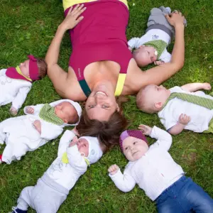 Diana Frosch liegt im Gras mit Babys